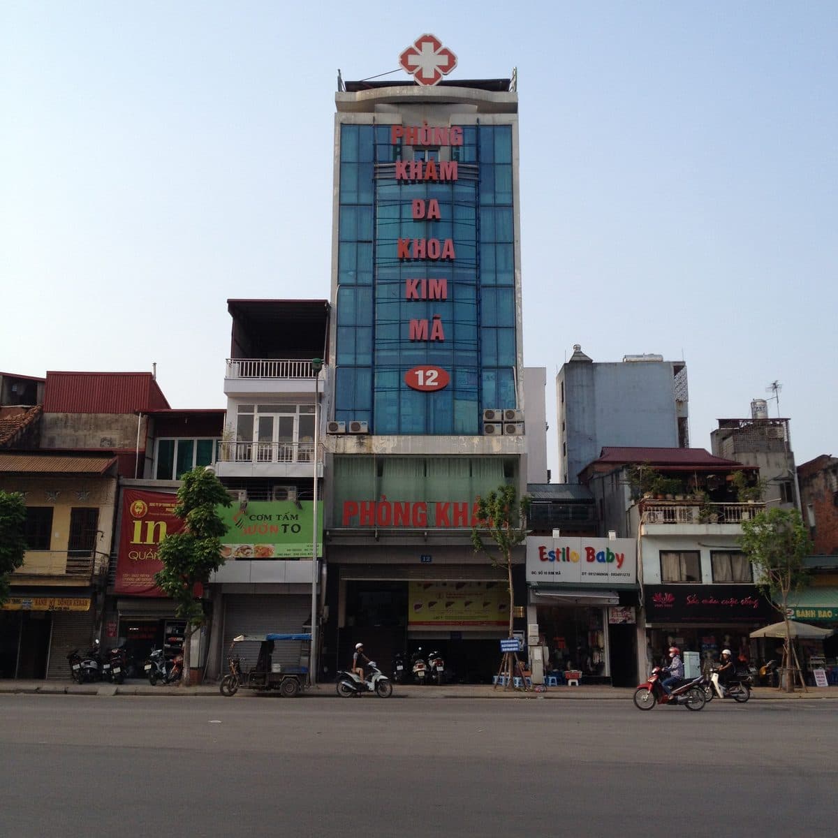 Многоэтажная поликлиника с красным крестом и вывеской Phòng khám đa khoa Kim Mã на улице Ханоя