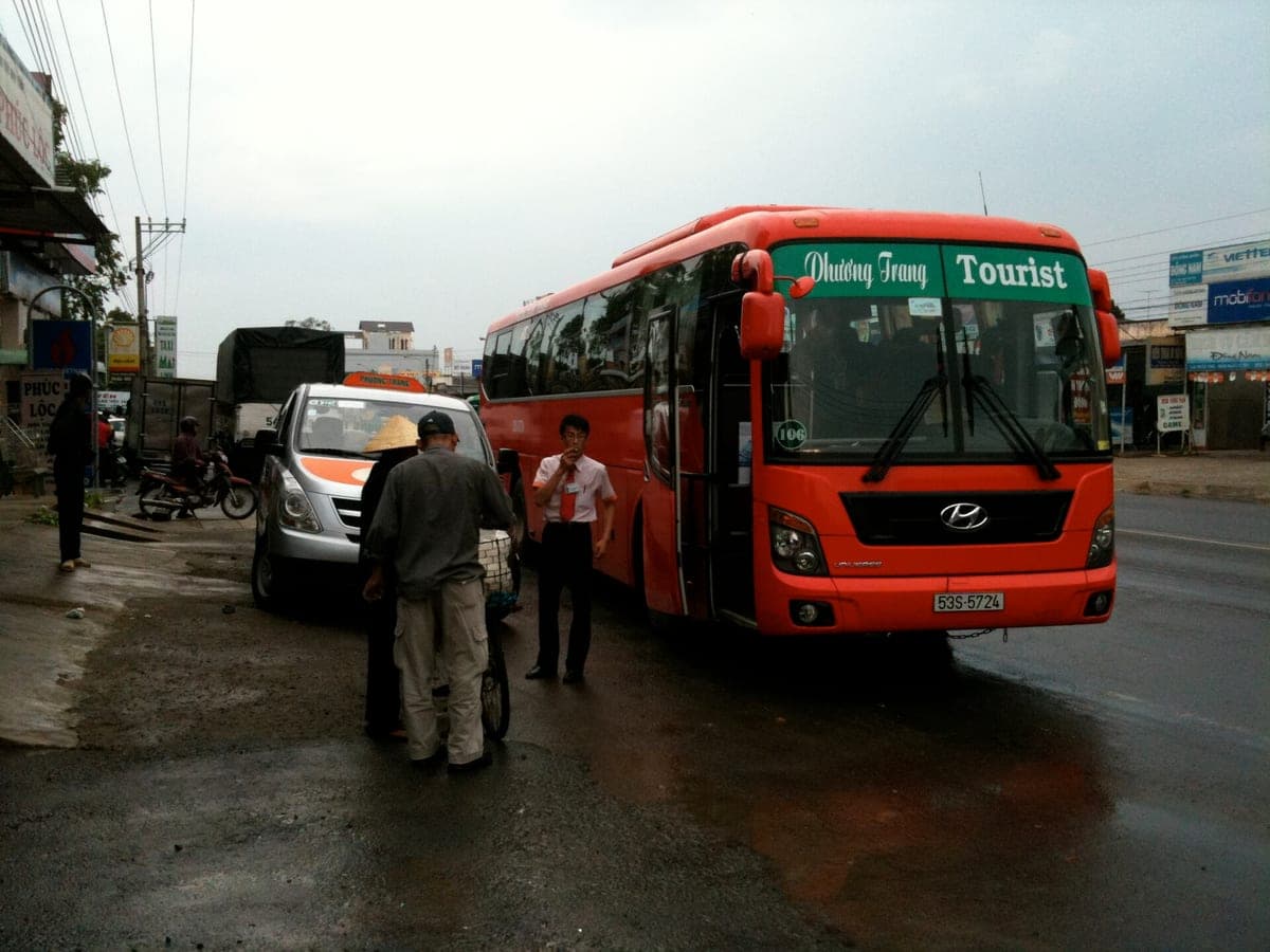 Красный междугородний автобус Phương Trang на остановке у трассы