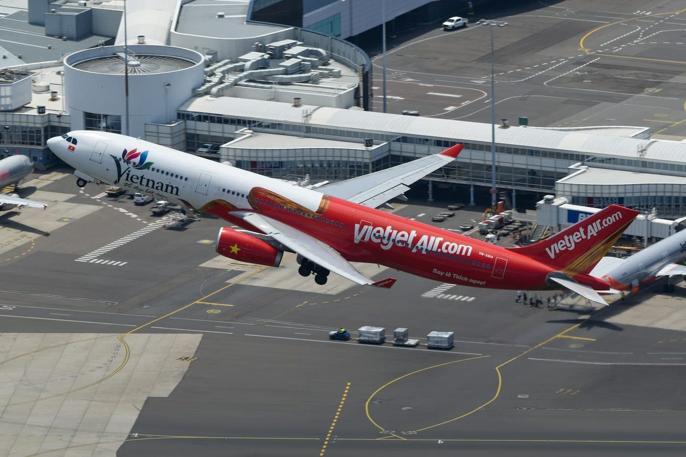 Широкофюзеляжный самолёт VietJet Air взлетает над перроном аэропорта