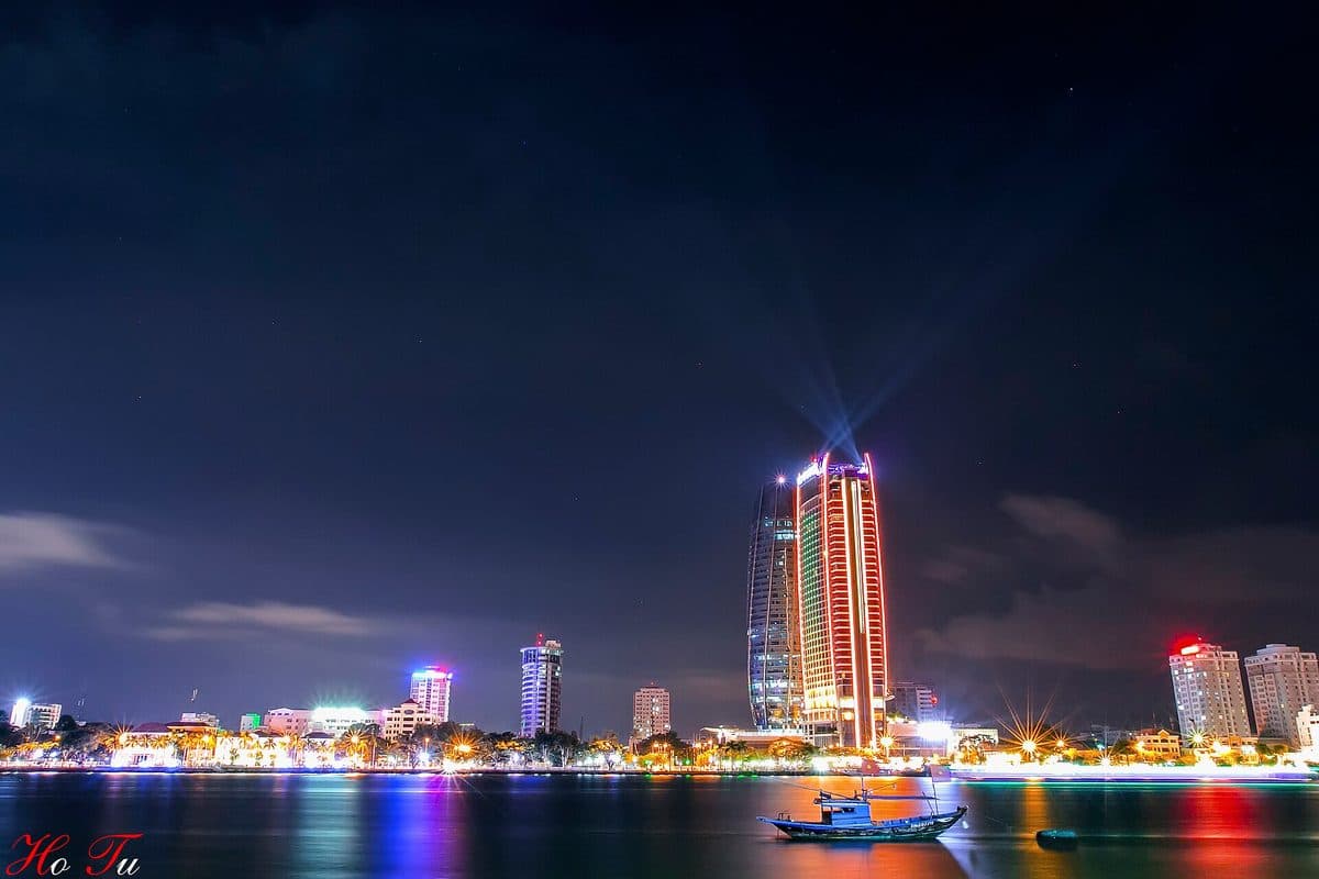 Подсвеченная башня Novotel и отели на набережной реки Хан в Дананге ночью