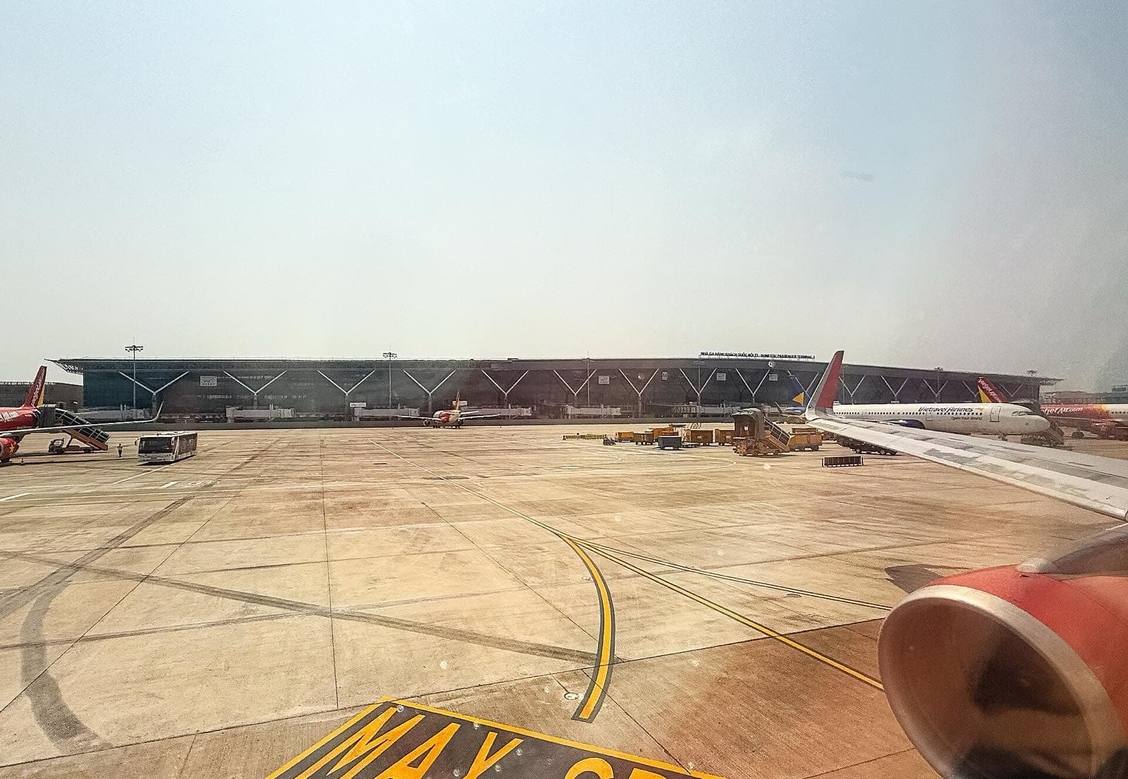 Терминал T3 аэропорта Таншоннят со стороны перрона, у здания самолёты Vietjet и Vietravel Airlines