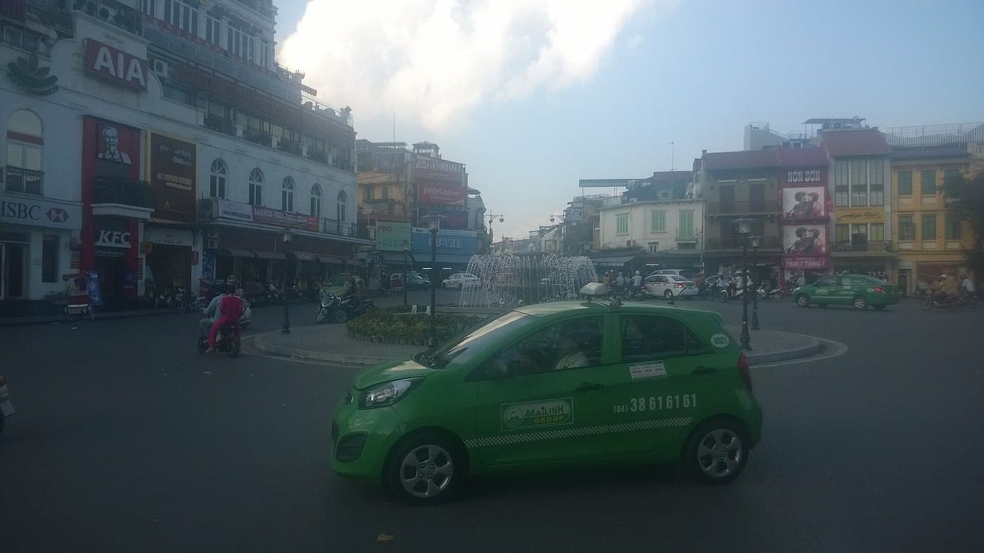 Зелёное такси Mai Linh на круговой развязке у озера Хоанкьем в Ханое